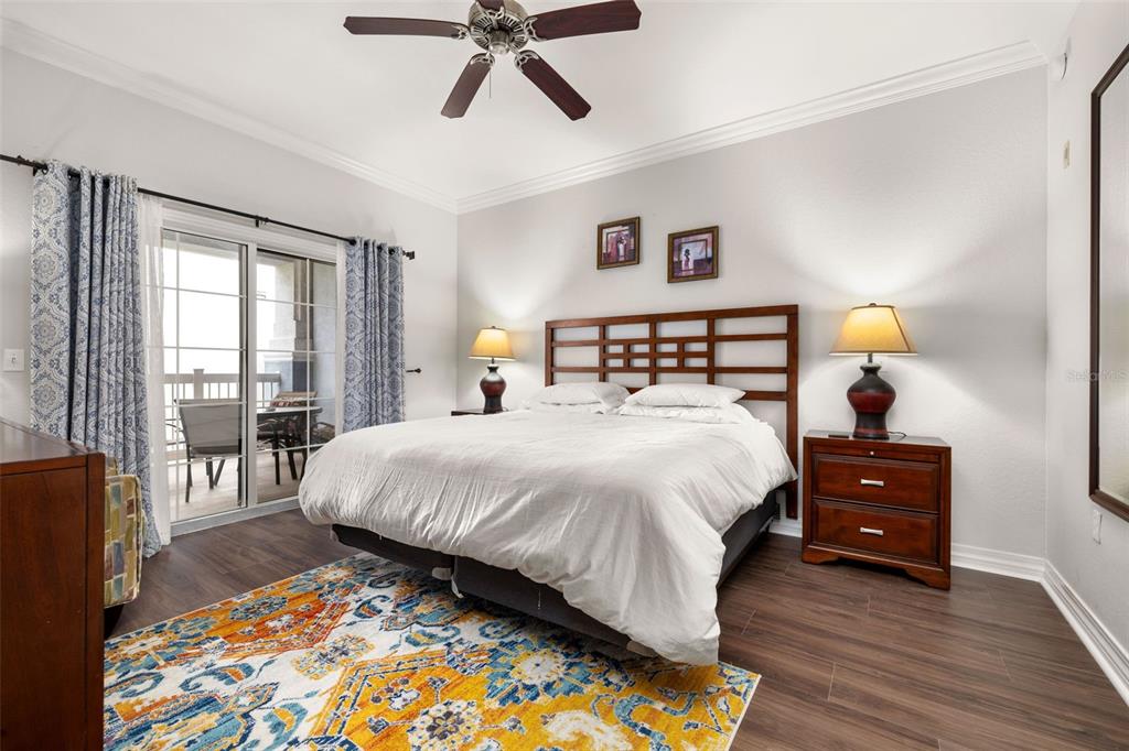 1100 Sunset View Circle, Unit 302 Reunion, FL 34747 - Photo 23 of 56 a bedroom with a bed and wooden floor