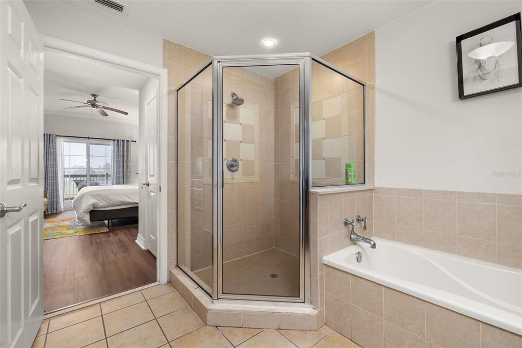 1100 Sunset View Circle, Unit 302 Reunion, FL 34747 - Photo 28 of 56 a spacious bathroom with a glass shower door and a bathtub