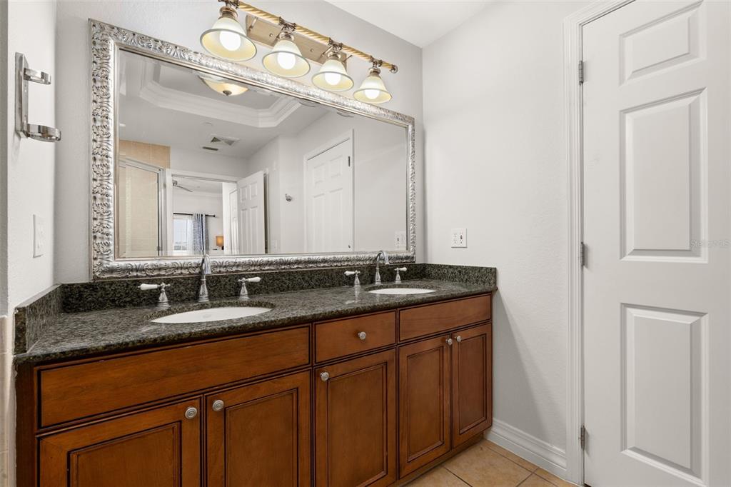 1100 Sunset View Circle, Unit 302 Reunion, FL 34747 - Photo 29 of 56 a bathroom with double sink and a mirror