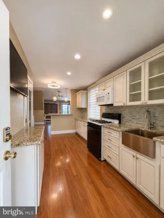 a large kitchen with stainless steel appliances kitchen island granite countertop a sink and cabinets