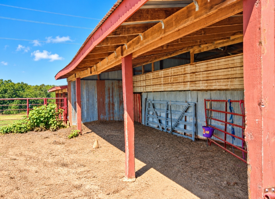 12526 3520th Road Seminole, OK 74868 - Photo 32 of 42 Spacious covered structure featuring red metal framing, wooden beam ceiling, and corrugated metal siding