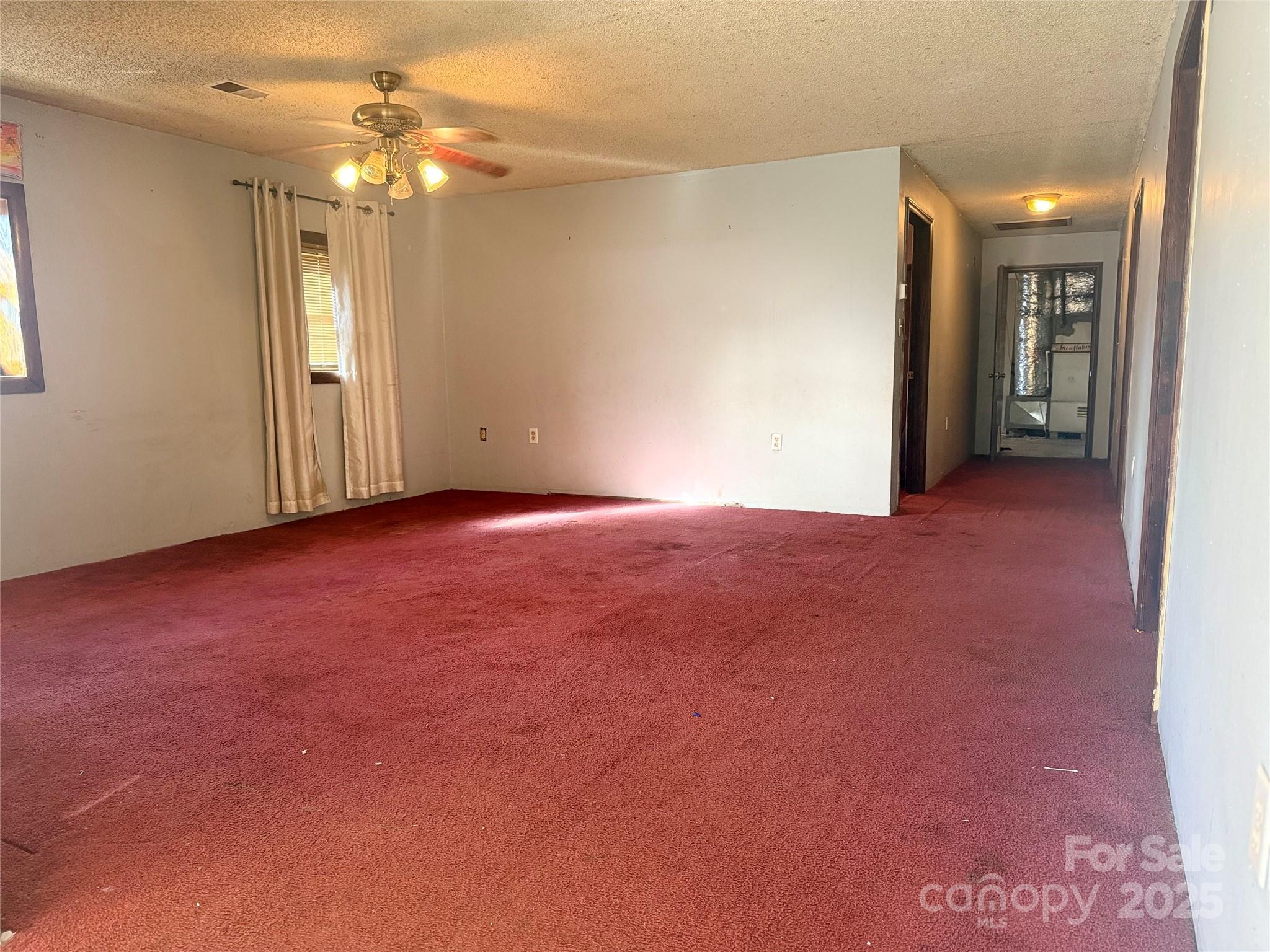 138 Rash Road Lincolnton, NC 28092 - Photo 9 of 41 an empty room with chandelier fan and windows