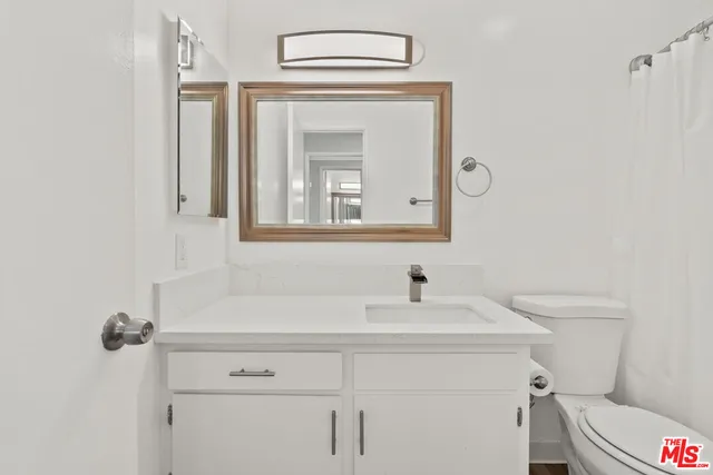 a bathroom with a sink vanity and toilet
