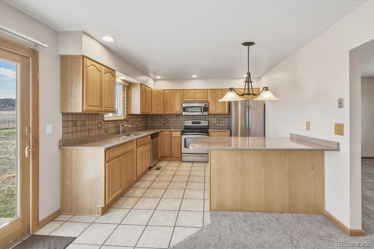 12720 South Mesa View Road Larkspur, CO 80118 - Photo 13 of 45 a large kitchen with cabinets