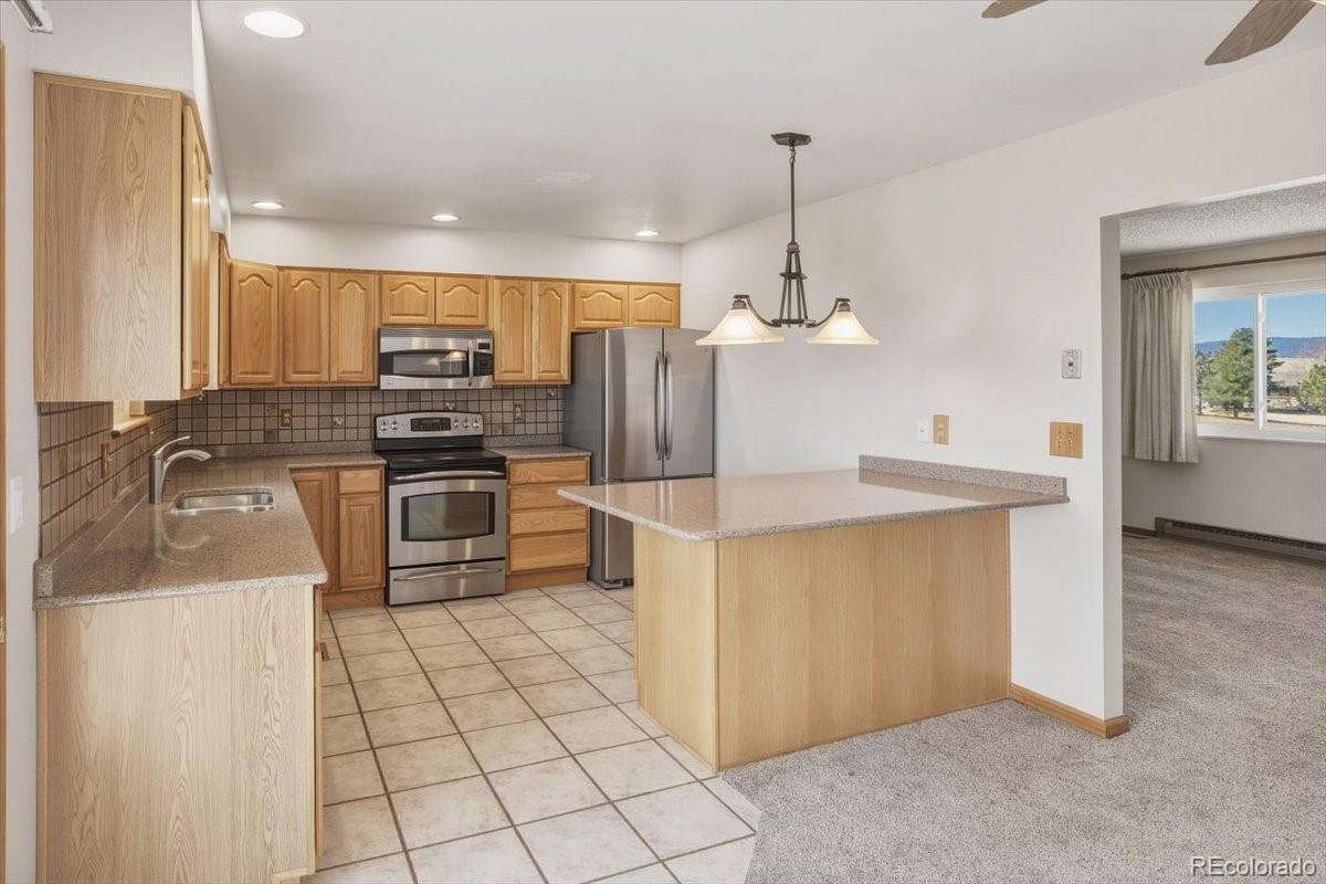 12720 South Mesa View Road Larkspur, CO 80118 - Photo 14 of 45 a kitchen with stainless steel appliances granite countertop a sink a stove and a refrigerator