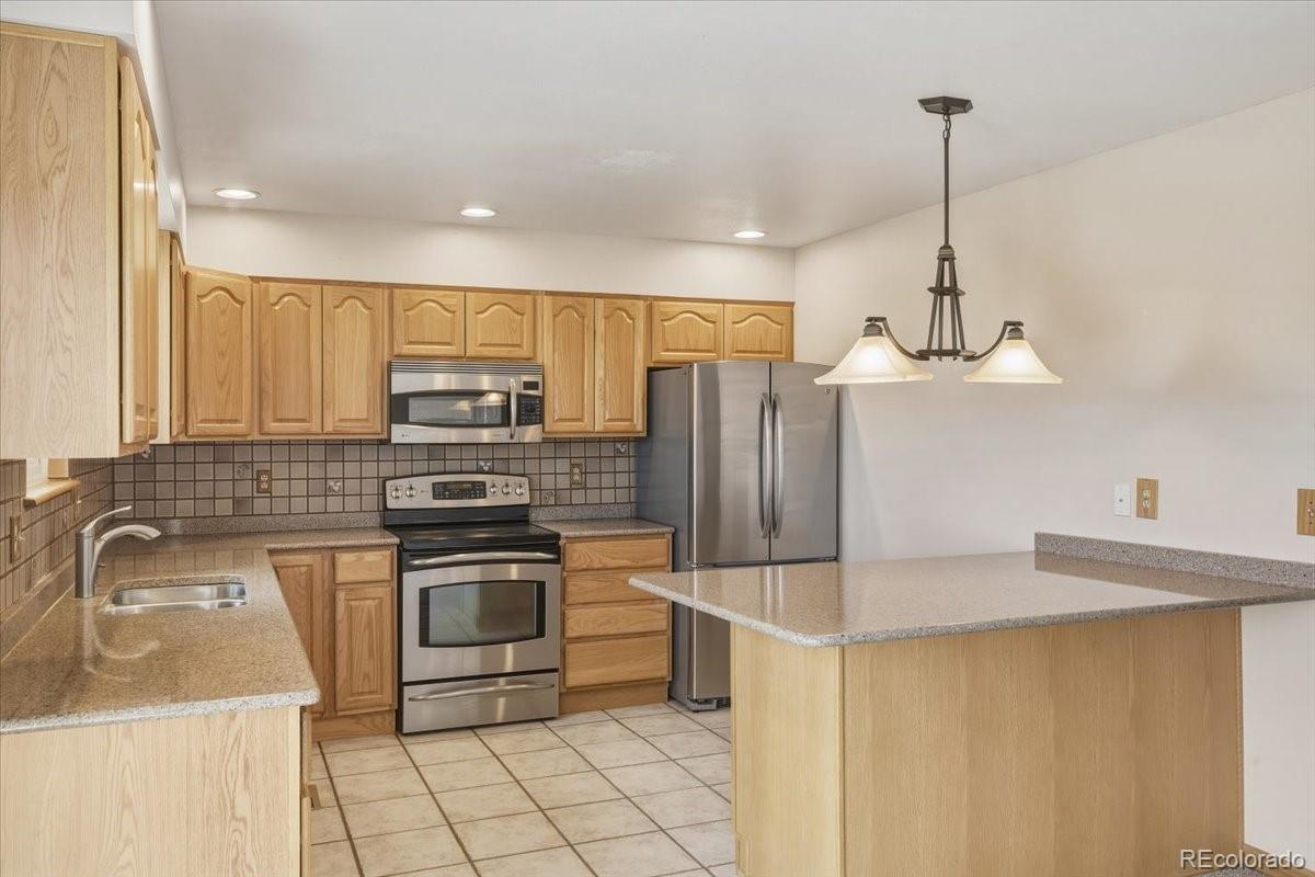 12720 South Mesa View Road Larkspur, CO 80118 - Photo 15 of 45 a kitchen with stainless steel appliances granite countertop a sink a stove a refrigerator and island