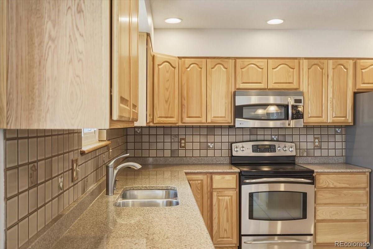 12720 South Mesa View Road Larkspur, CO 80118 - Photo 16 of 45 a kitchen with granite countertop a sink and a stove top oven