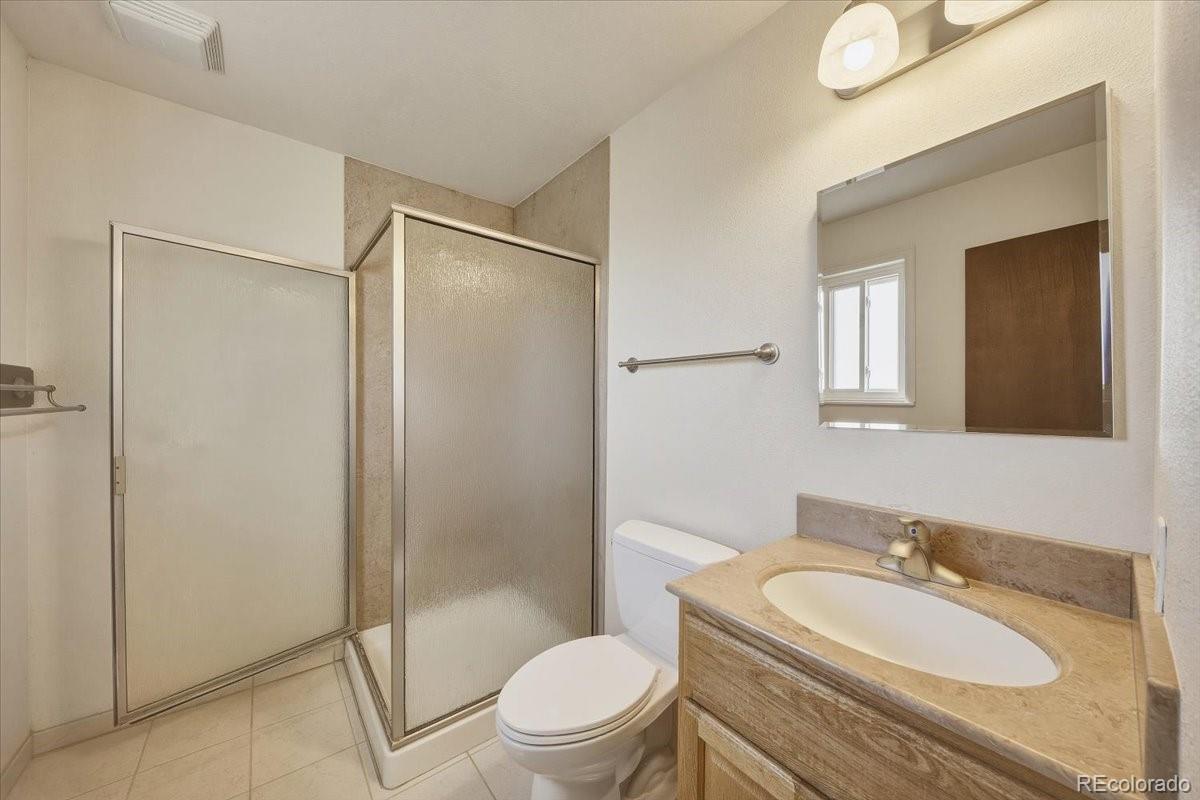 12720 South Mesa View Road Larkspur, CO 80118 - Photo 20 of 45 a bathroom with a granite countertop sink toilet mirror and shower