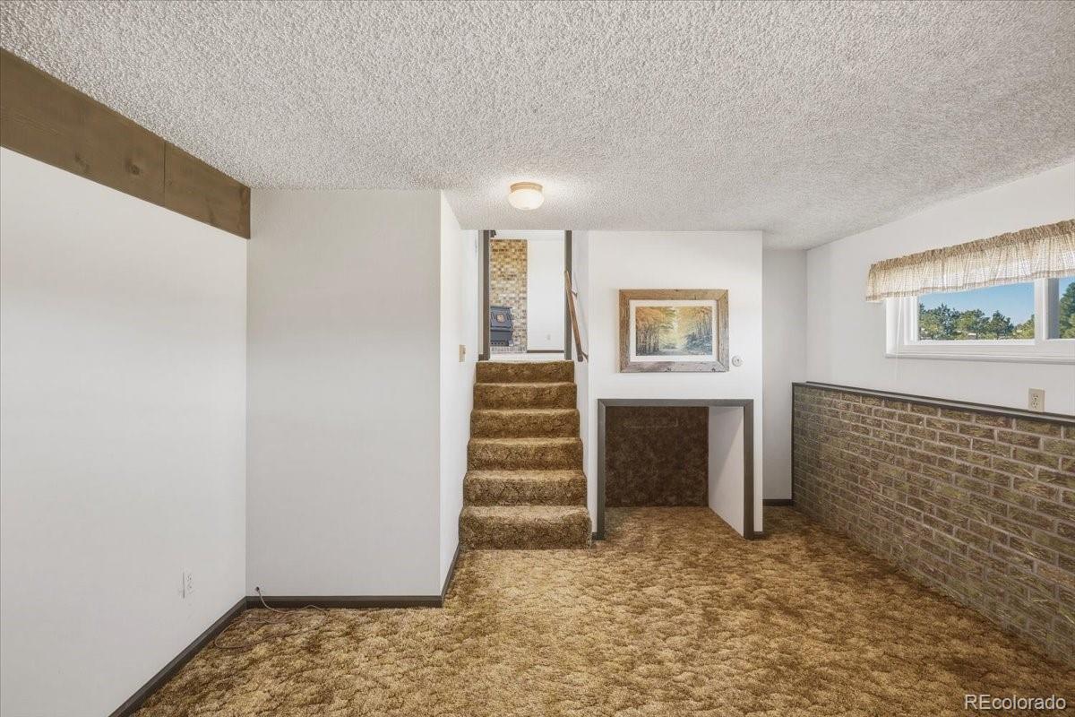 12720 South Mesa View Road Larkspur, CO 80118 - Photo 26 of 45 a view of an empty room with stairs and furniture