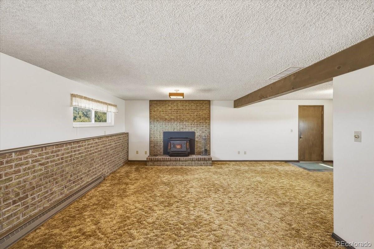 12720 South Mesa View Road Larkspur, CO 80118 - Photo 27 of 45 a view of an empty room with a fireplace