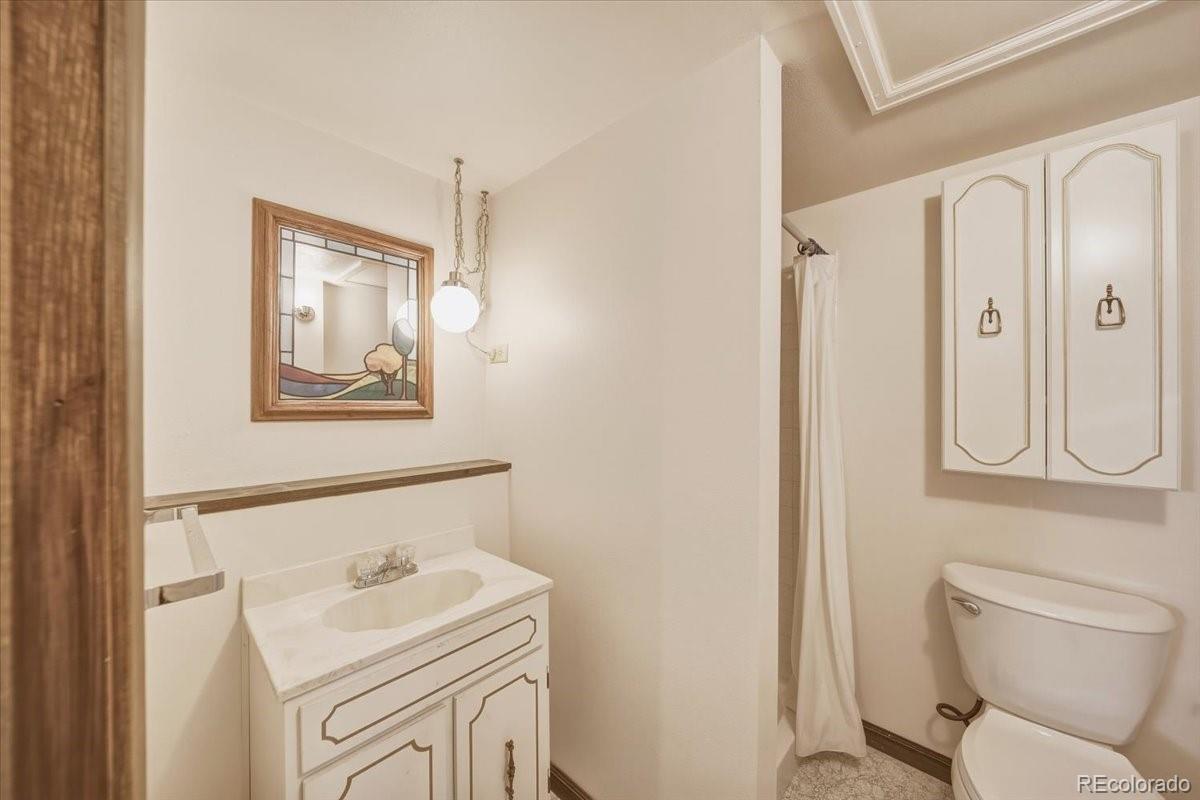 12720 South Mesa View Road Larkspur, CO 80118 - Photo 33 of 45 a bathroom with a toilet sink and mirror