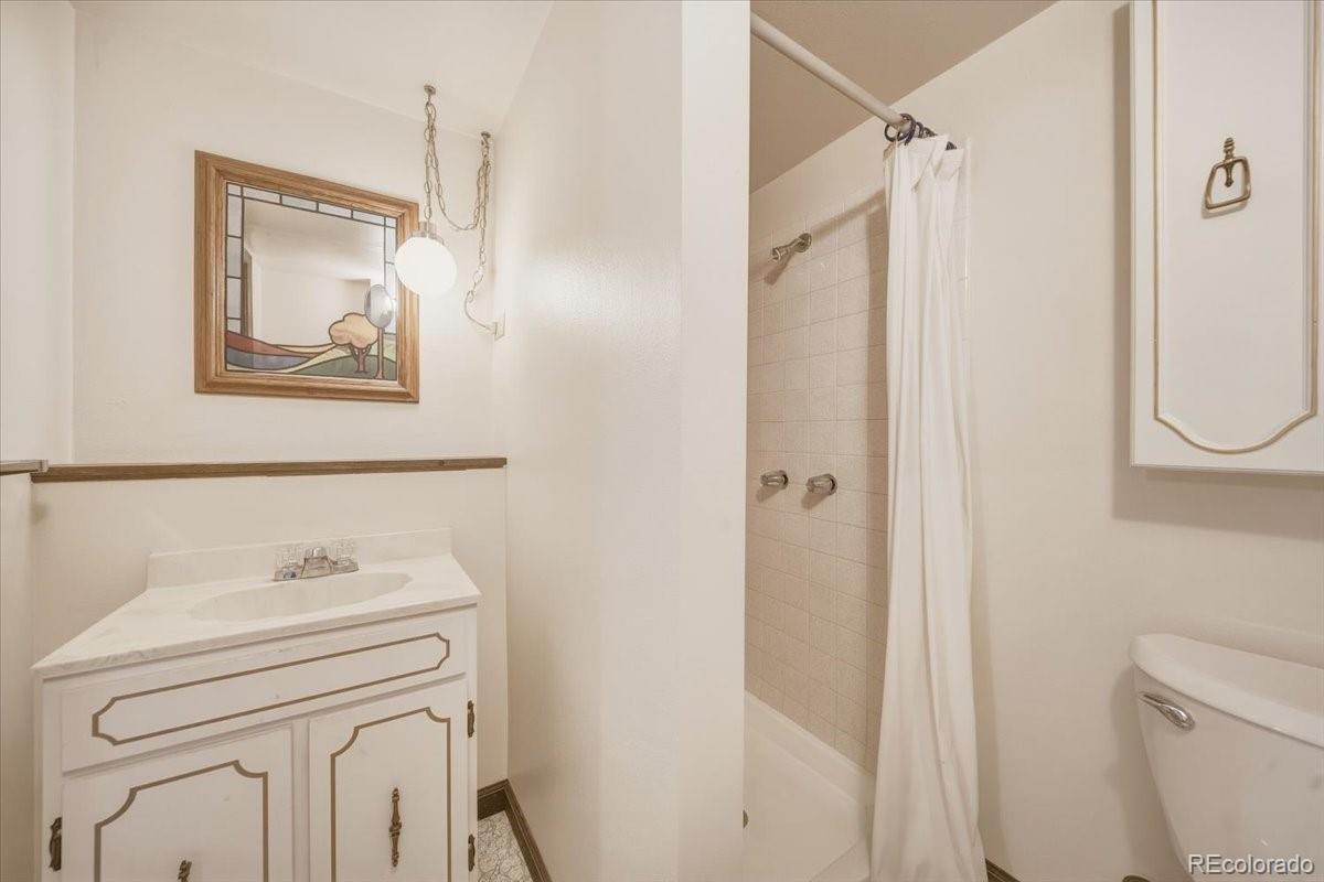 12720 South Mesa View Road Larkspur, CO 80118 - Photo 34 of 45 a bathroom with a sink a toilet and a mirror