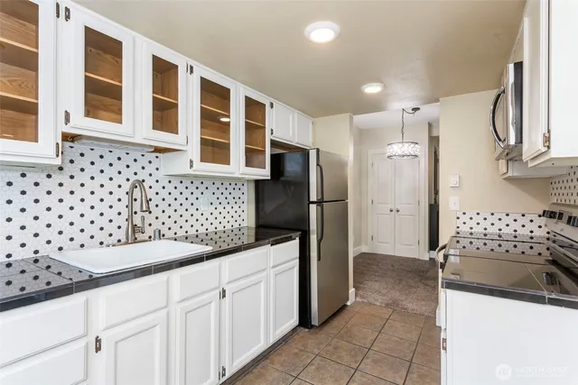a kitchen with granite countertop a refrigerator and a sink