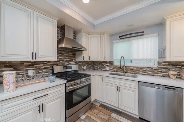 a kitchen with stainless steel appliances granite countertop a sink stove oven and white cabinets