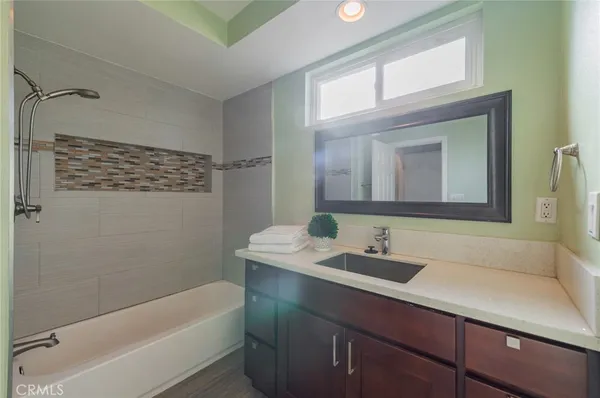 a bathroom with a sink a bathtub a mirror and vanity