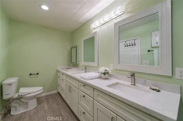 a bathroom with a double vanity sink toilet and mirror