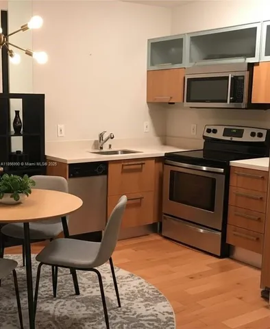 a kitchen with stainless steel appliances a stove a sink and a microwave