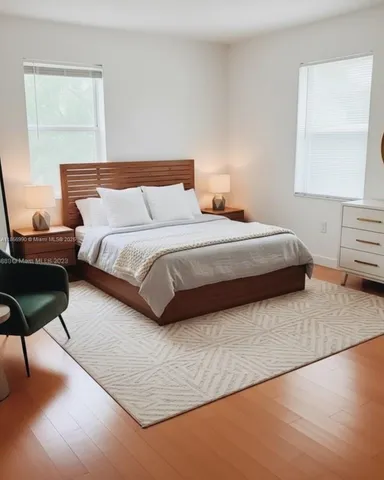 a bedroom with a bed a lamp and a large window