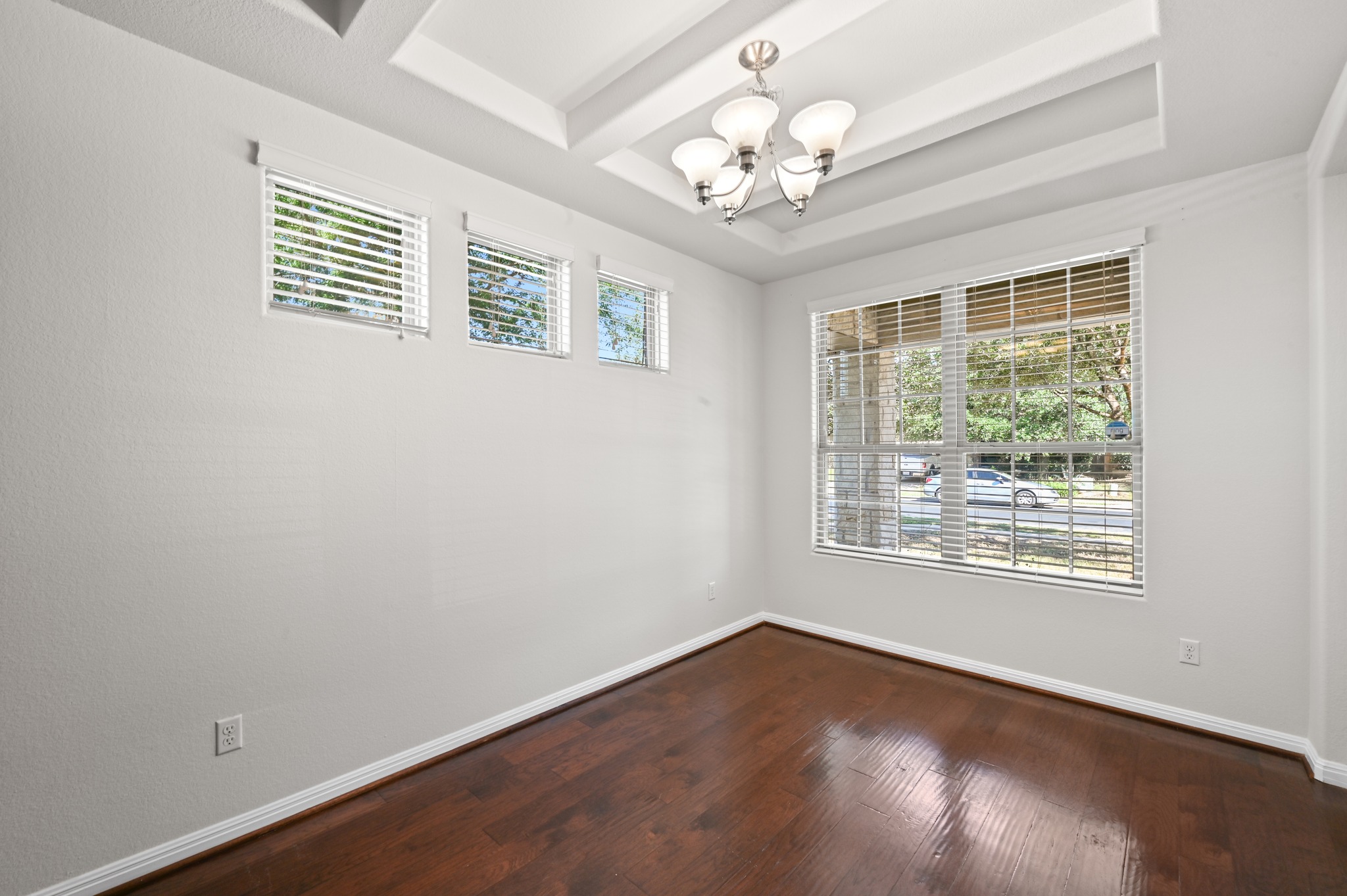351 Wincliff Drive Buda, TX 78610 - Photo 12 of 40 Elegant tray ceilings crown a formal dining space featuring gleaming hardwood floors and abundant natural illumination.