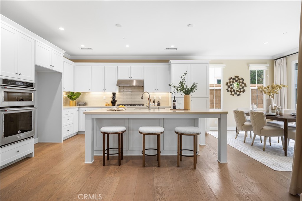 114 Omar Irvine, CA 92620 - Photo 5 of 25 a kitchen with granite countertop a table chairs stove a sink and dishwasher