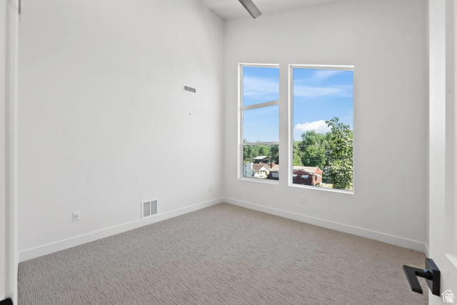 545 East 7215 South Midvale, UT 84047 - Photo 19 of 27 Carpeted spare room featuring baseboards and a high ceiling