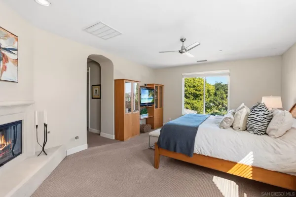 a bedroom with a large bed and a chandelier