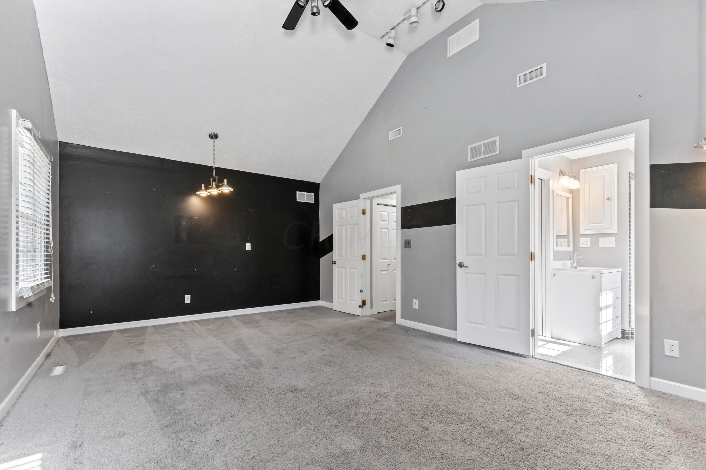 9495 Kilbourne Road Sunbury, OH 43074 - Photo 42 of 84 • Light grey carpet
• Black & grey painted walls
• Cathedral ceiling
• Closet with built-in drawers
& double sliding doors
• Lighted ceiling fan
• Track lighting
• (2) hanging lights