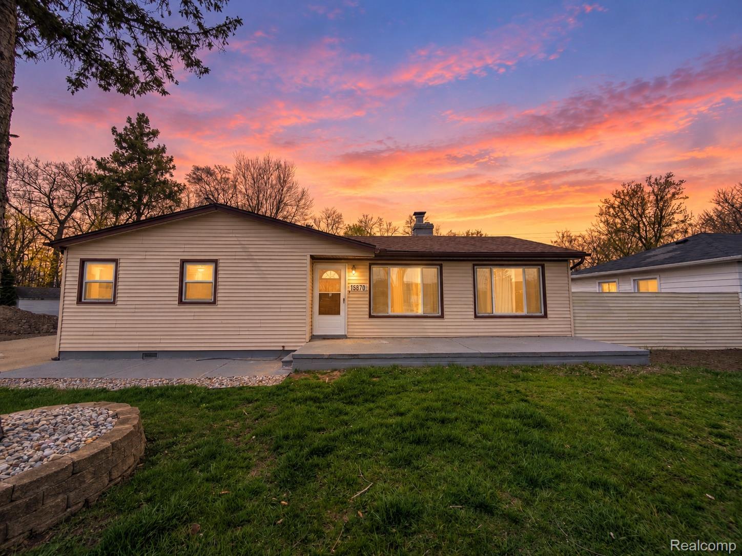 Siding exterior with multiple windows, featuring a front entry door and a small front porch
