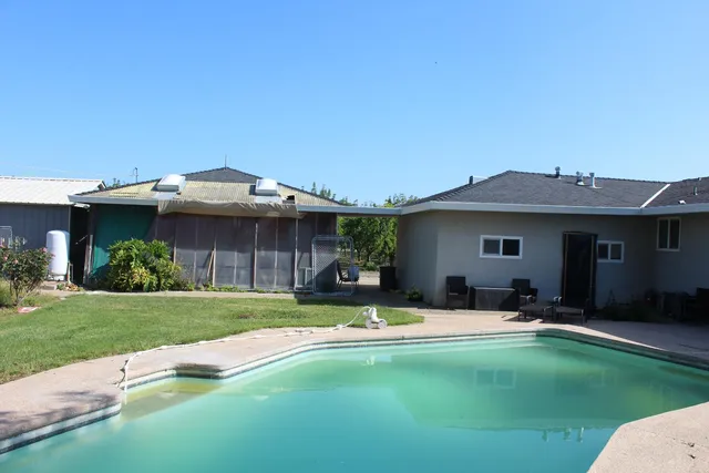a view of a house with a yard patio and fire pit