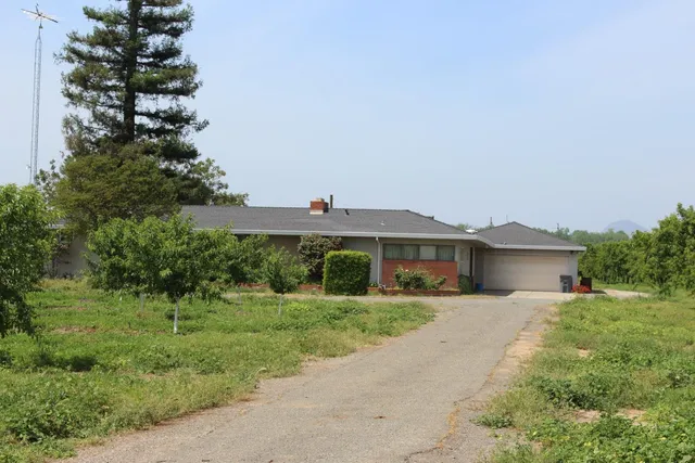 a front view of a house with a yard and potted plants
