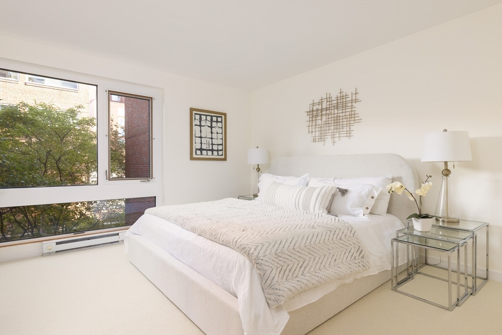975 Memorial Drive, Unit 209 Cambridge, MA 02138 - Photo 11 of 23 a bedroom with a large bed and a window