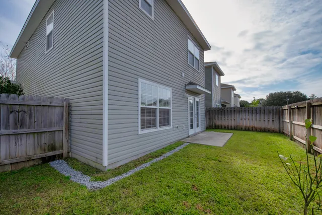 a view of a house with a yard and potted plants