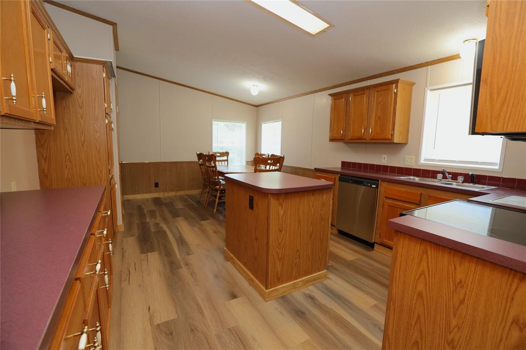 191 Circle Drive Mansfield, LA 71052 - Photo 10 of 22 a kitchen with kitchen island granite countertop a sink stove and wooden cabinets
