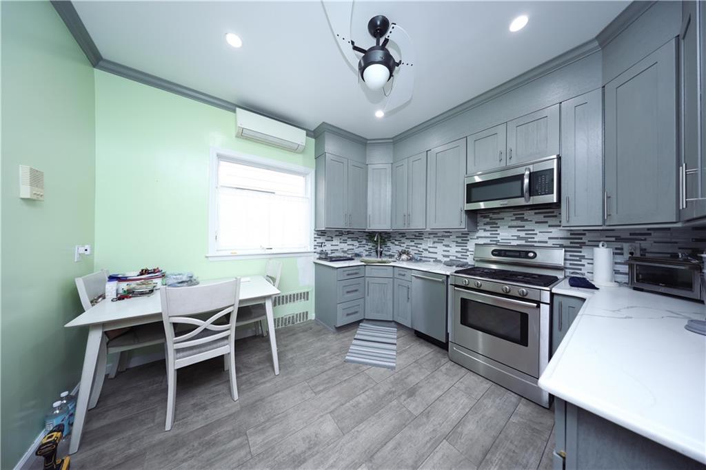 1049 Bay Ridge Parkway Brooklyn, NY 11228 - Photo 13 of 41 a kitchen with stainless steel appliances kitchen island granite countertop a stove top oven a sink dishwasher a dining table and chairs with wooden floor