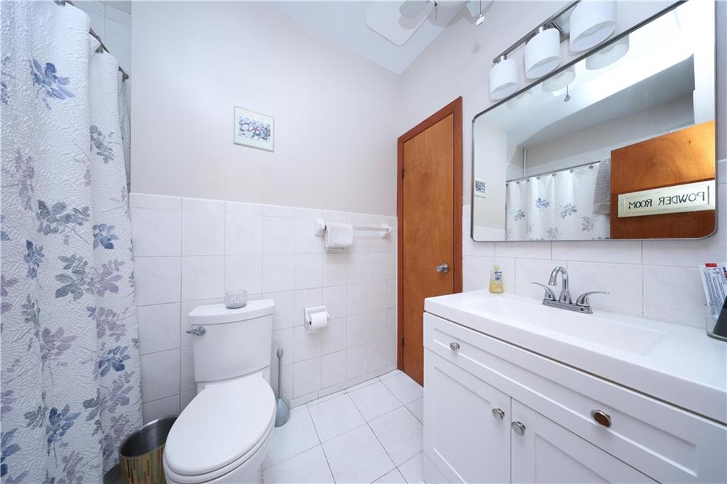 1049 Bay Ridge Parkway Brooklyn, NY 11228 - Photo 15 of 41 a bathroom with a sink a toilet and a mirror