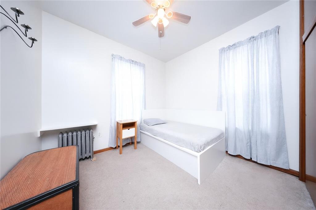1049 Bay Ridge Parkway Brooklyn, NY 11228 - Photo 16 of 41 a bedroom with a bed and a chandelier