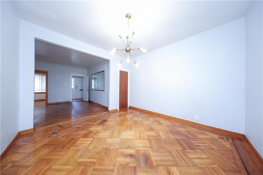 1049 Bay Ridge Parkway Brooklyn, NY 11228 - Photo 21 of 41 a view of a hallway with wooden floor and a chandelier