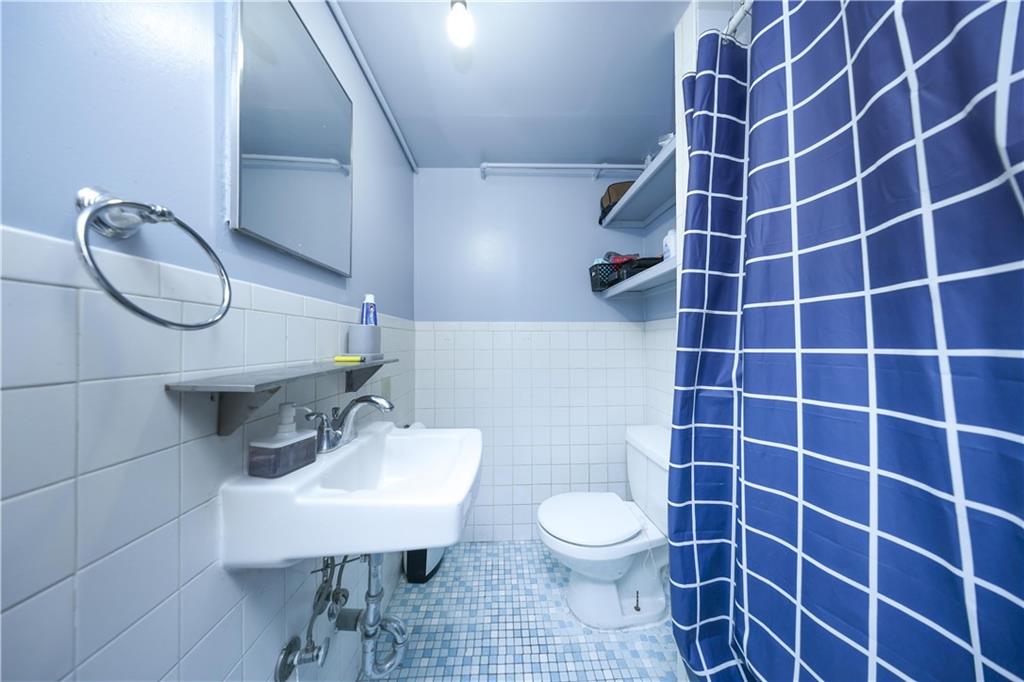 1049 Bay Ridge Parkway Brooklyn, NY 11228 - Photo 32 of 41 a bathroom with a sink a toilet and a mirror