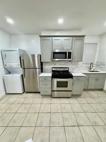 a kitchen with stainless steel appliances a stove a sink and a refrigerator