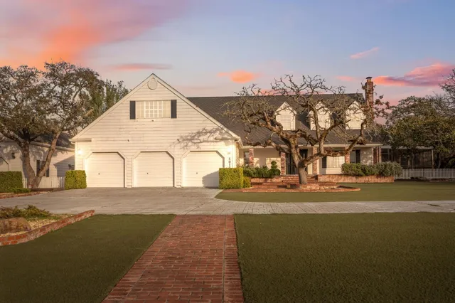 a view of a white house with a yard