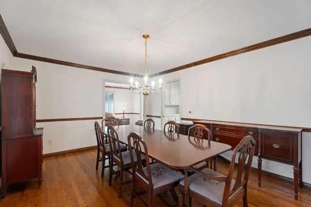 a dining room with furniture a flat screen tv and wooden floor