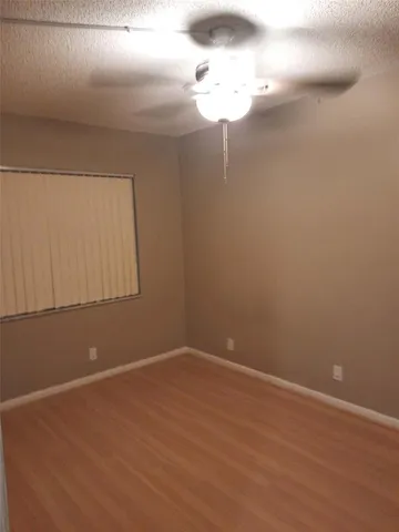 a view of an empty room with a chandelier fan