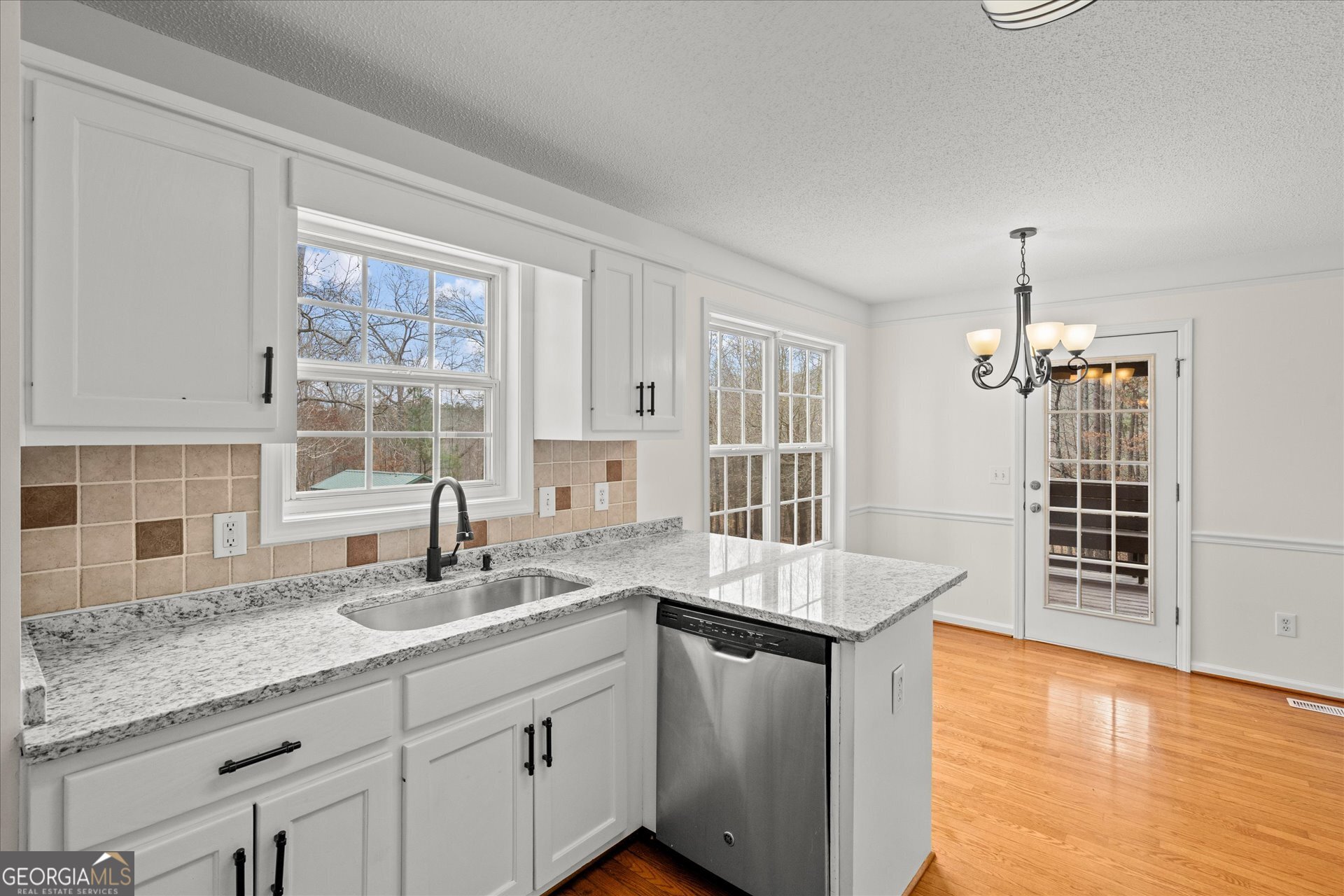 401 Tapley Road Villa Rica, GA 30180 - Photo 15 of 42 a kitchen with granite countertop a sink and dishwasher with wooden floor