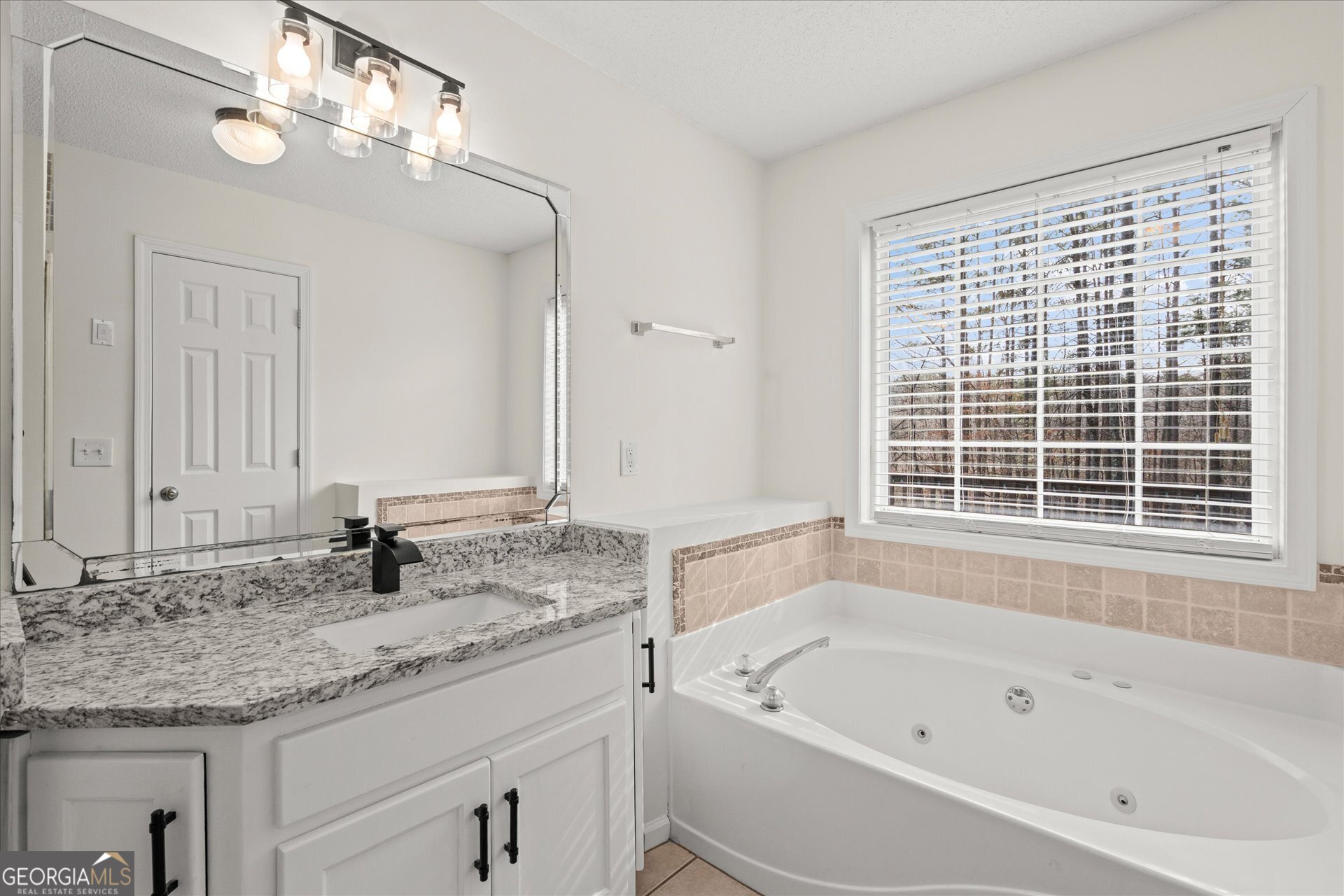 401 Tapley Road Villa Rica, GA 30180 - Photo 25 of 42 a bathroom with a granite countertop tub a sink and a large mirror