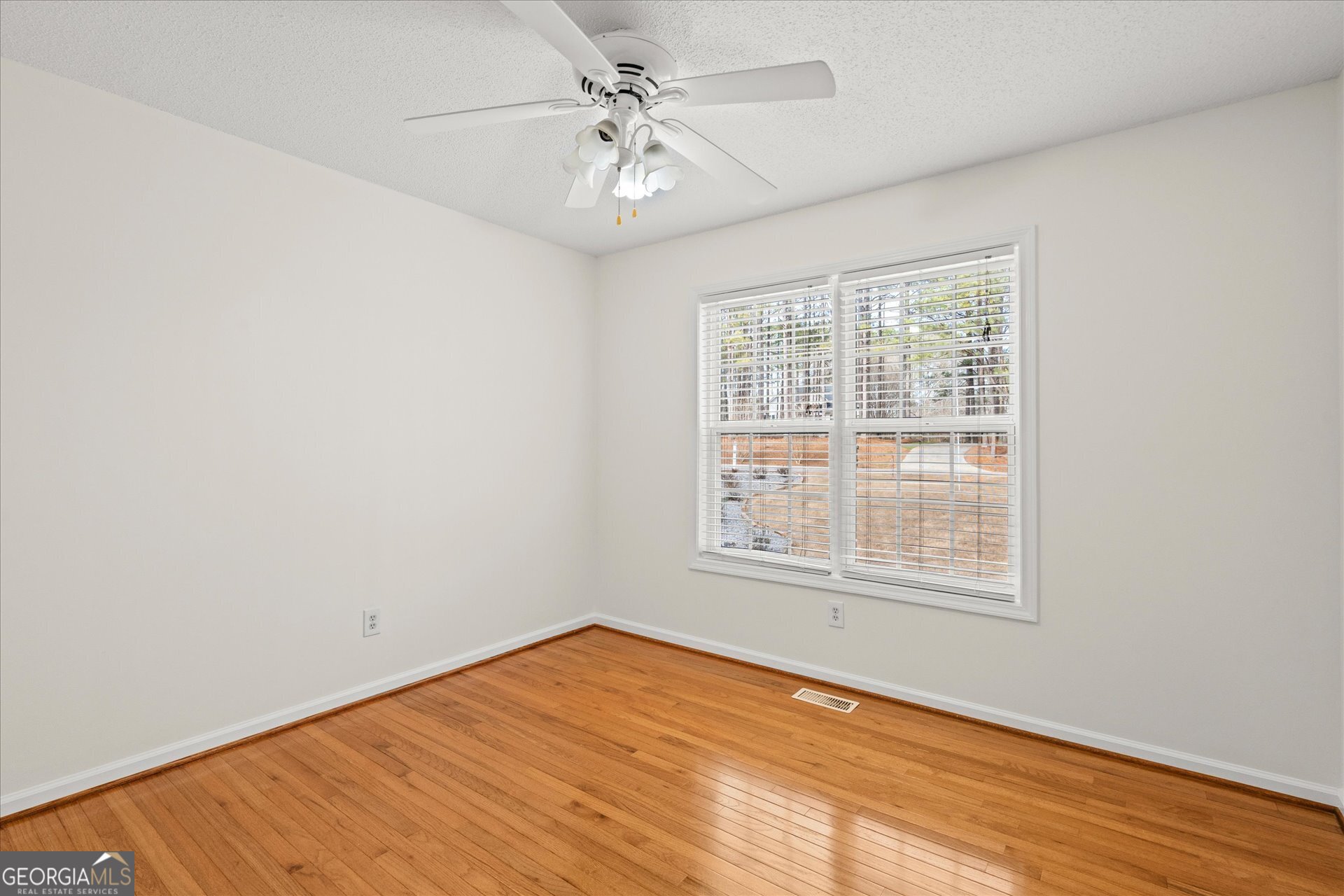 401 Tapley Road Villa Rica, GA 30180 - Photo 27 of 42 an empty room with wooden floor fan and windows