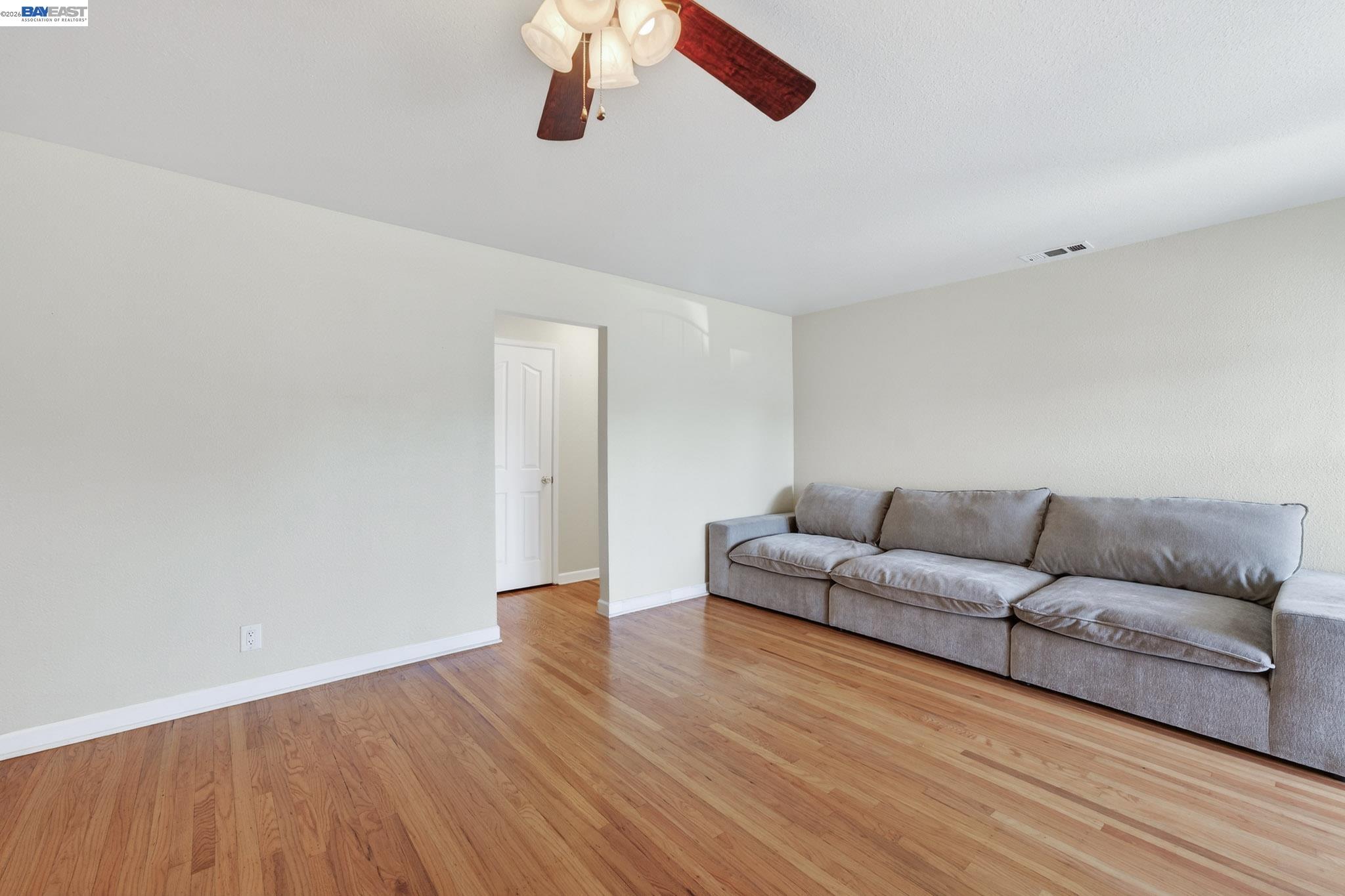 6759 Albyn Court Newark, CA 94560 - Photo 5 of 23 a living room with couches and a ceiling fan with wooden floor