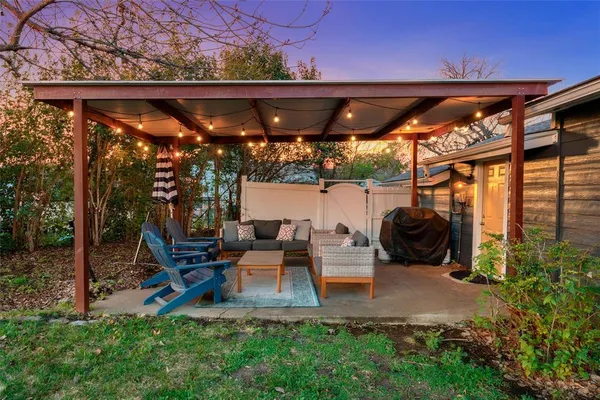 a view of patio with table and chairs under an umbrella