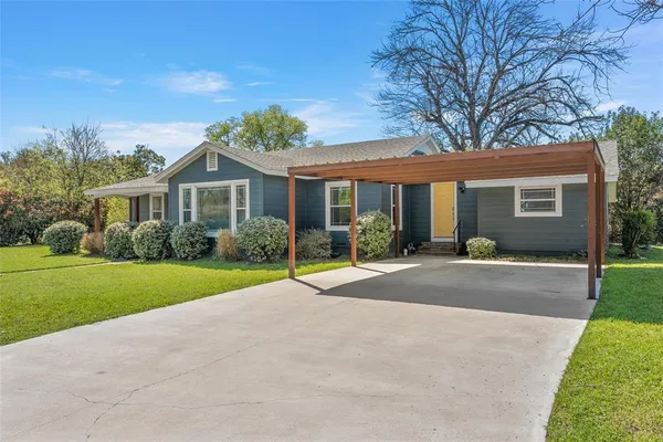 a view of a house with a yard and potted plants