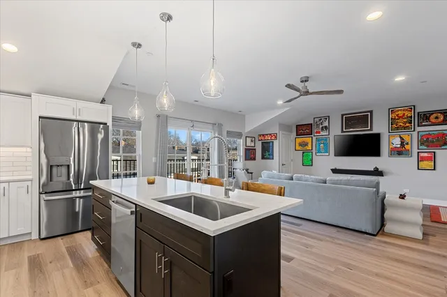 a kitchen with stainless steel appliances granite countertop a sink a stove and a refrigerator