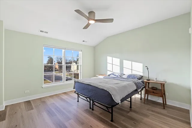 a bed sitting in a spacious bedroom next to a window